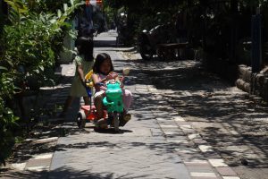 Glückliches Kind auf seinem Fahrrad in Surabaya