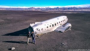 Flugzeugwrack in Island mit Bergkulisse im Hintergrund