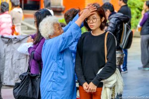 Junge Frau wird in Taipeh in einem Tempel gesegnet