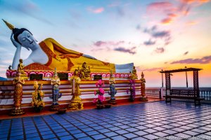 Liegende Buddhastatue mit Sonnenaufgang im Hintergrund